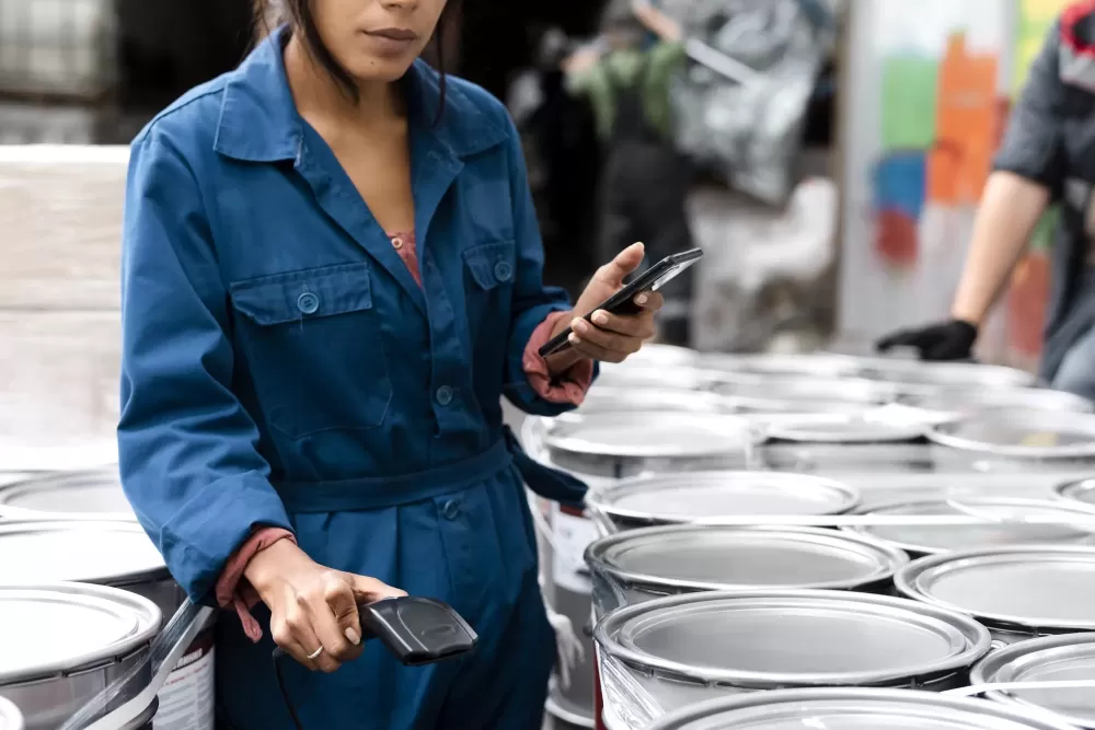 دانلود عکس زن جوان در حال کنترل محصولات در انبار